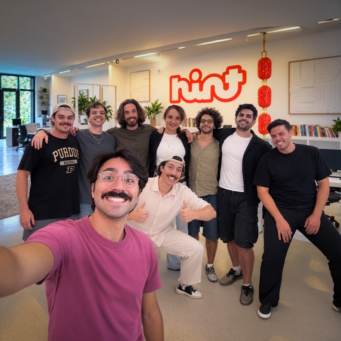 Il team di Hint in ufficio, sotto l'insegna al neon