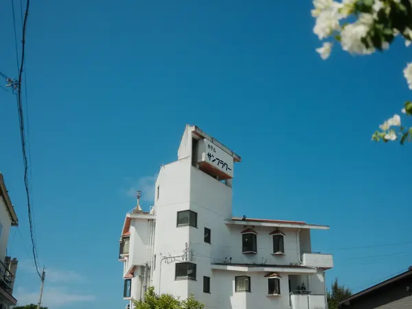 Una casa bianca sotto il cielo di Okinawa, con le bouganville